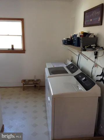 a utility room with stainless steel appliances granite countertop a sink and wooden cabinets