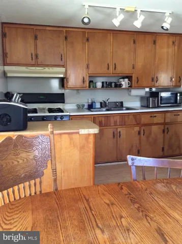 a kitchen with stainless steel appliances granite countertop a sink a stove and white cabinets