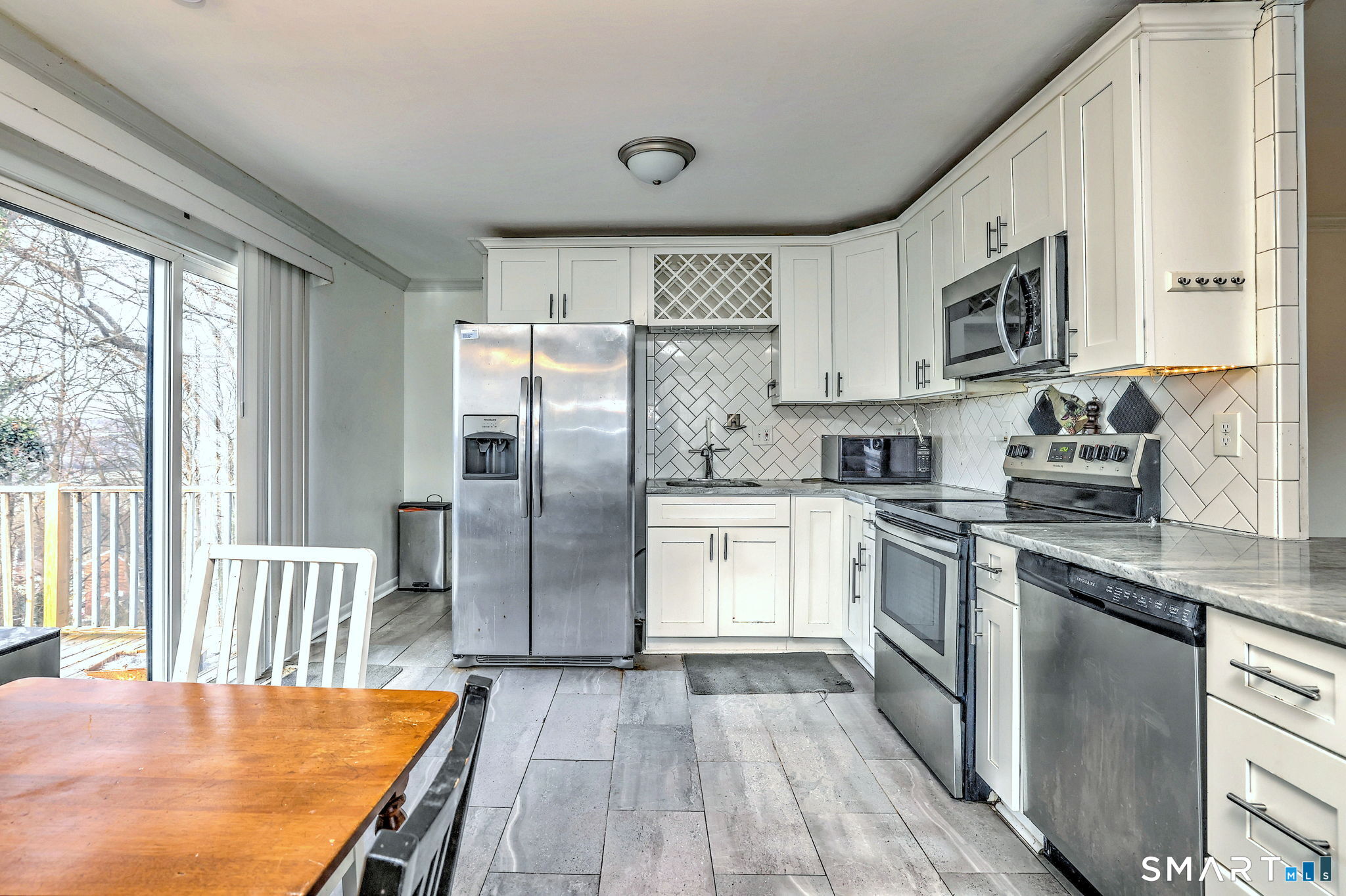 42 Highland Avenue Ansonia, CT 06401 - Photo 13 of 40 a kitchen with stainless steel appliances granite countertop a refrigerator a stove top oven a sink dishwasher and white cabinets with wooden floor