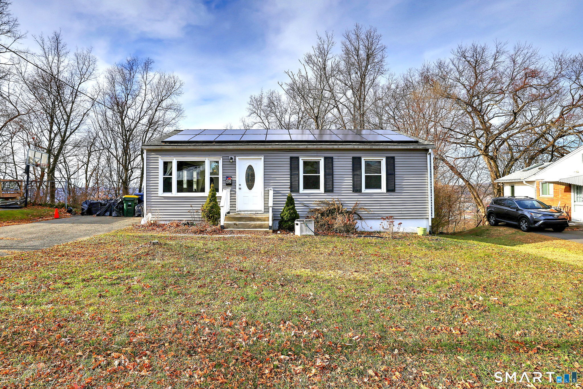 42 Highland Avenue Ansonia, CT 06401 - Photo 2 of 40 a front view of a house with a yard covered with trees