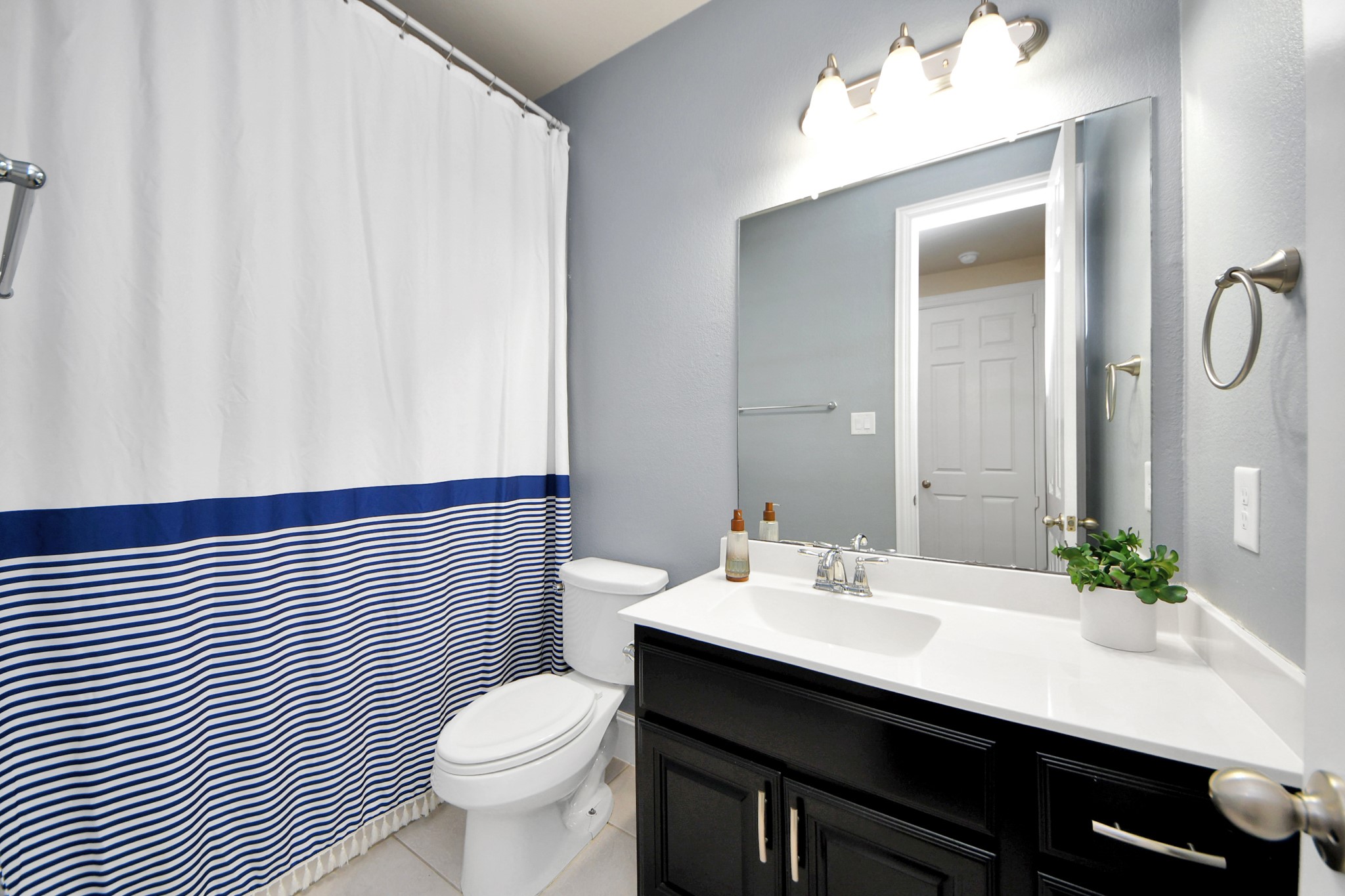 4811 Applewood Crest Lane Rosharon, TX 77583 - Photo 23 of 45 a bathroom with a sink a toilet a mirror and shower curtain