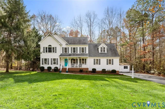 a front view of a house with a garden and trees