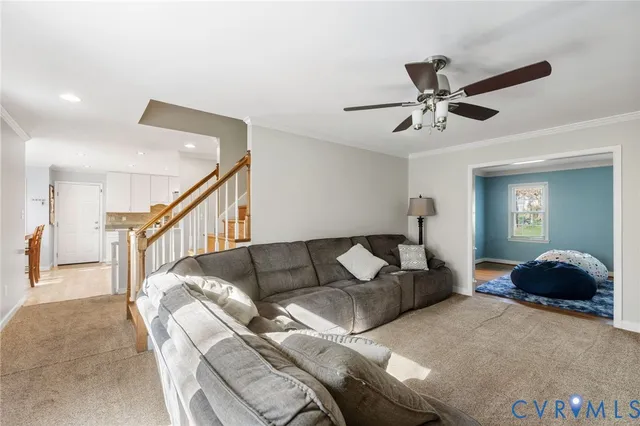 a living room with furniture and a ceiling fan