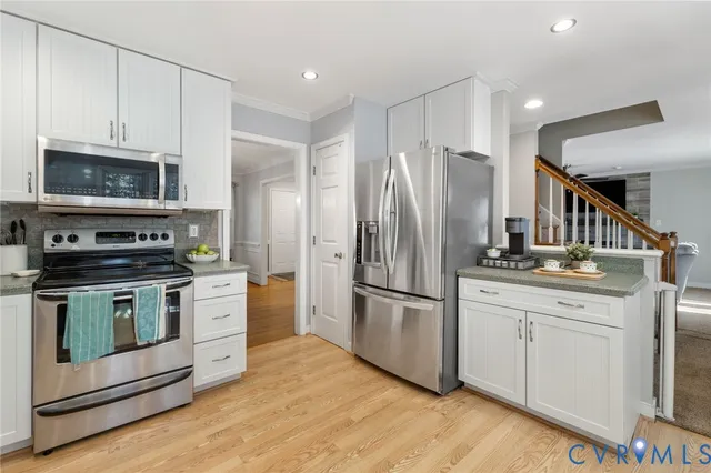 a kitchen with granite countertop a refrigerator stove and microwave