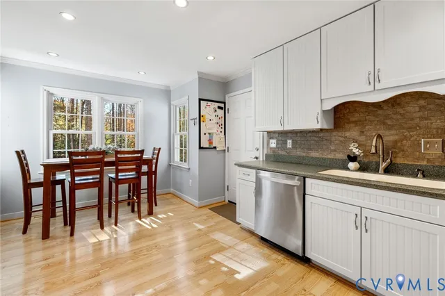 a kitchen with white cabinets and sink