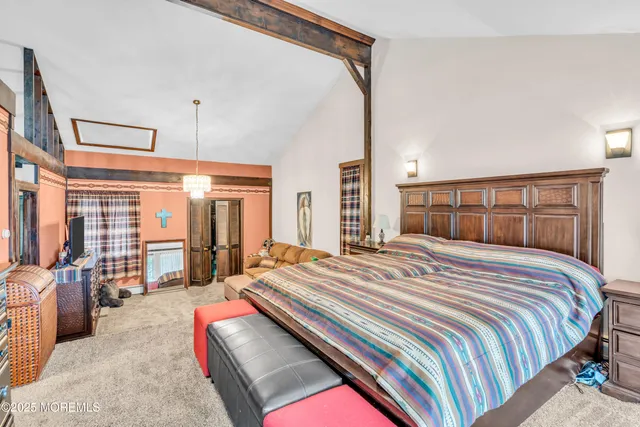 a bedroom with a bed couch and a large window