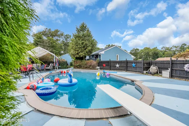 a view of house with swimming pool and furniture