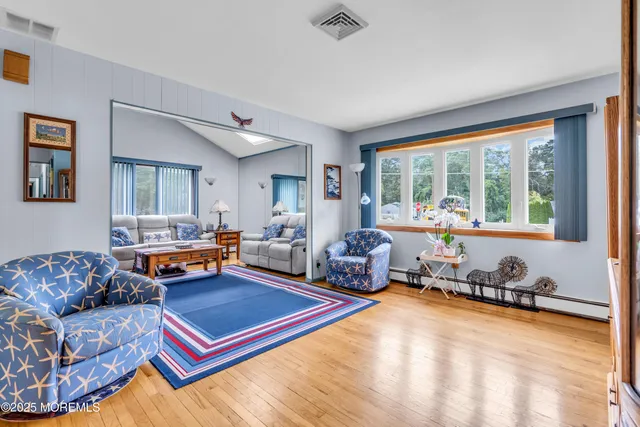 a living room with furniture a flat screen tv and a large window