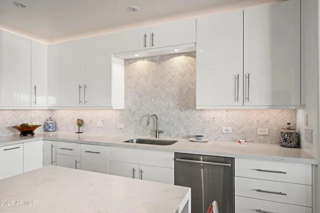 a large kitchen with stainless steel appliances kitchen island granite countertop a refrigerator oven a sink dishwasher and white cabinets next to a window