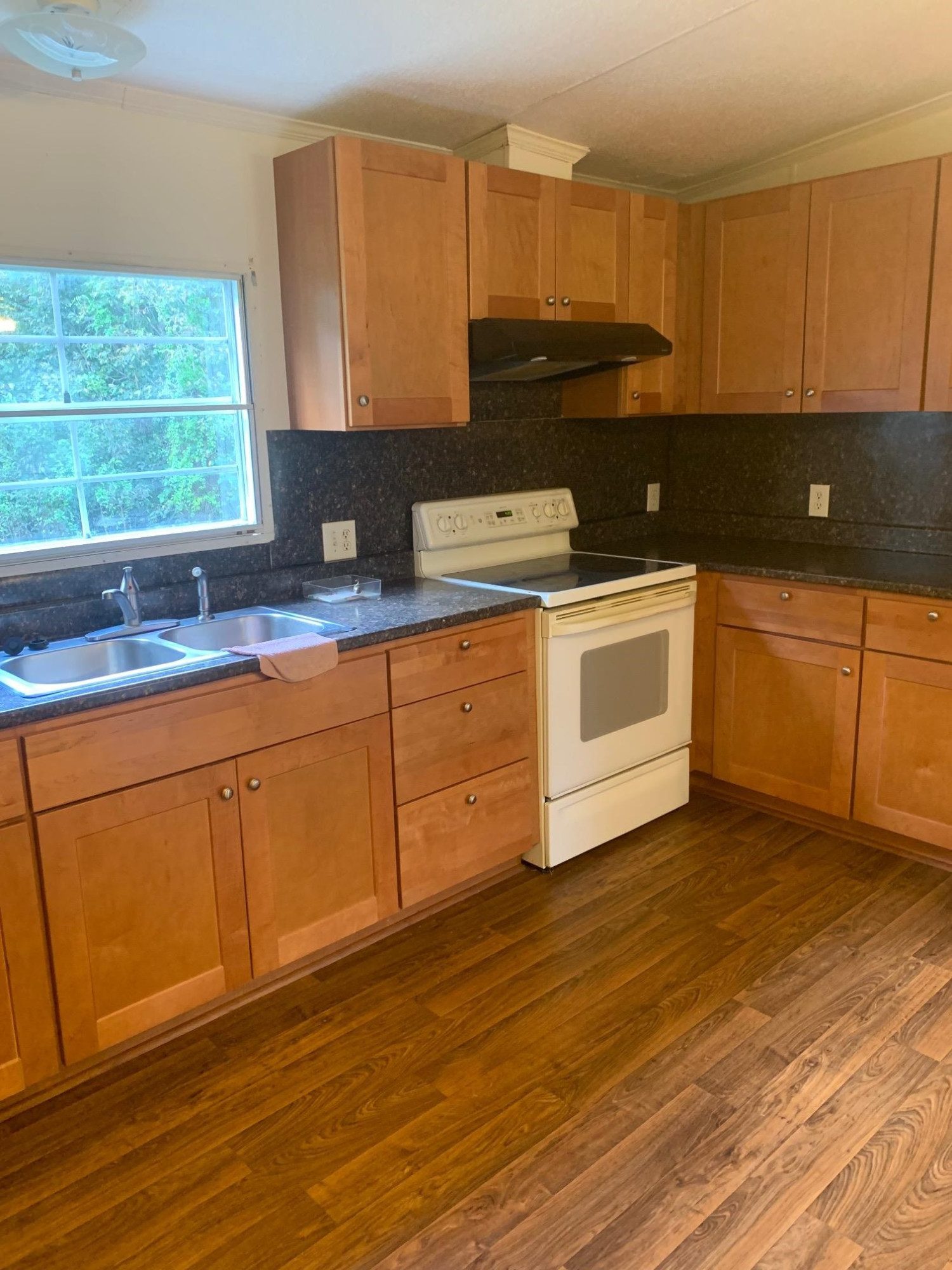 326 Everett Avenue Roxboro, NC 27574 - Photo 4 of 10 a kitchen with stainless steel appliances granite countertop a sink a stove cabinets and wooden floor