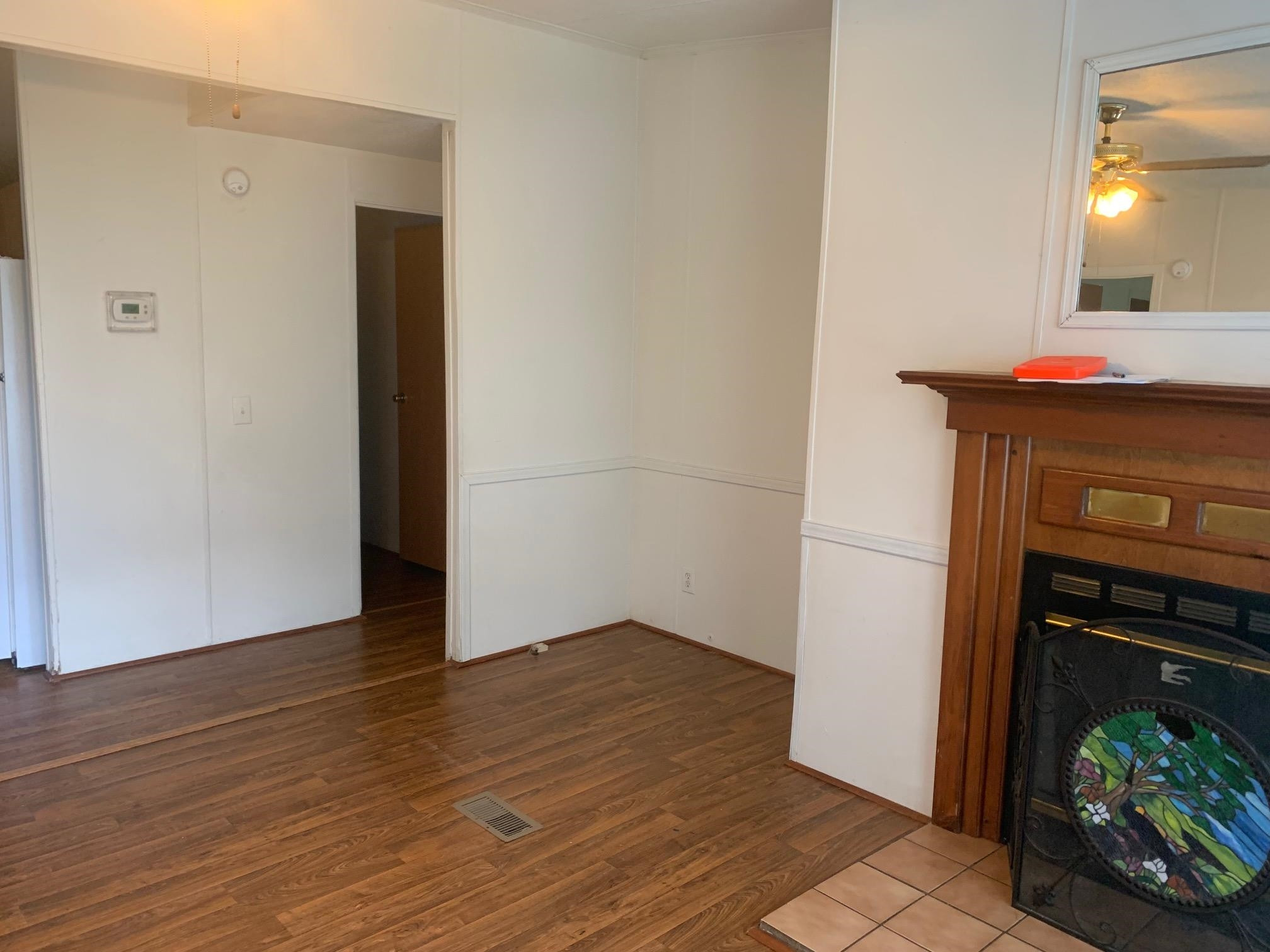 326 Everett Avenue Roxboro, NC 27574 - Photo 5 of 10 a view of an empty room with wooden floor and a fireplace