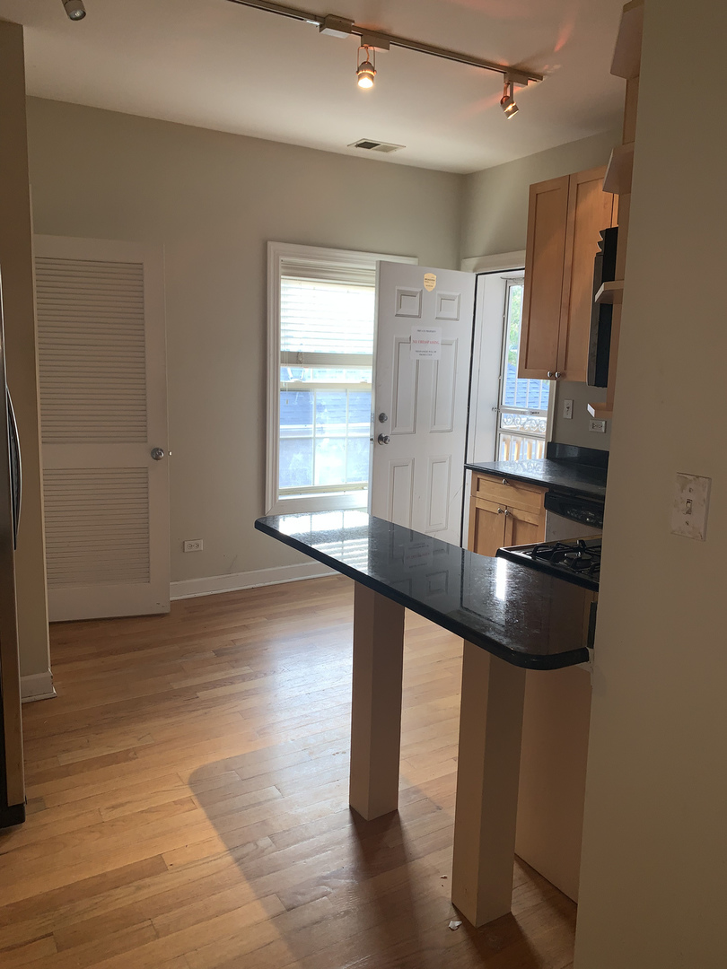 839 East 52nd Street, Unit 3 Chicago, IL 60615 - Photo 5 of 18 wooden floor in an empty room with a window