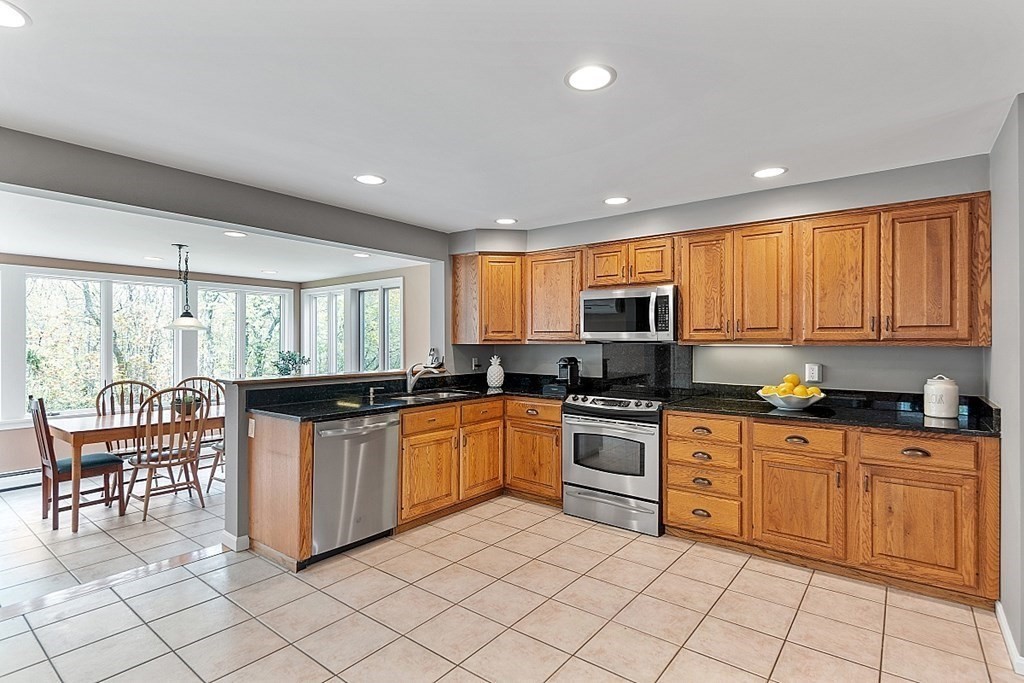 7 Cameron Road Harvard, MA 01451 - Photo 6 of 42 a kitchen with stainless steel appliances granite countertop a stove top oven a sink dishwasher a dining table and chairs with wooden floor