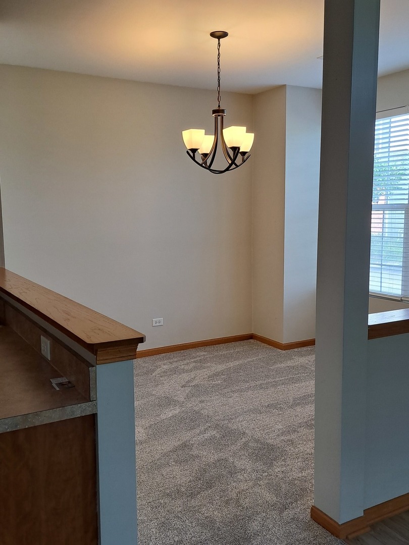 5111 Freeport Court Plainfield, IL 60586 - Photo 12 of 24 a view of an empty room with chandelier and a window