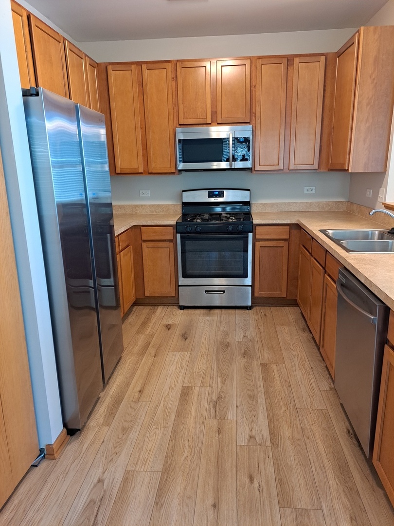 5111 Freeport Court Plainfield, IL 60586 - Photo 8 of 24 a kitchen with wooden cabinets and a stove top oven