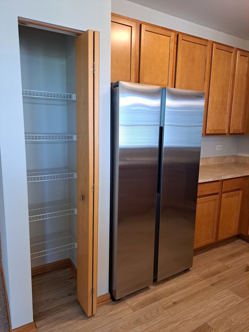 5111 Freeport Court Plainfield, IL 60586 - Photo 9 of 24 a kitchen with a refrigerator and wooden floor