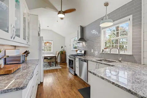 a kitchen with stainless steel appliances granite countertop sink stove top oven and cabinets
