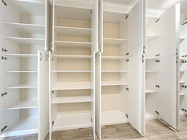 a view of walk in closet with empty racks