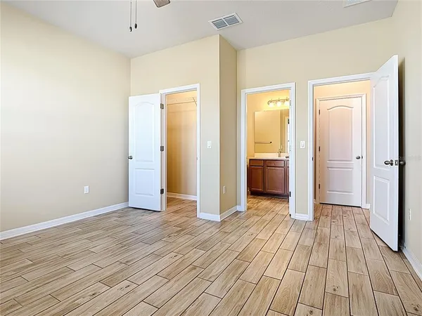 a view of a room with wooden floor and a bathroom