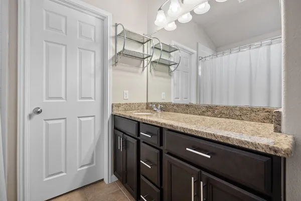 a bathroom with a granite countertop sink and a mirror