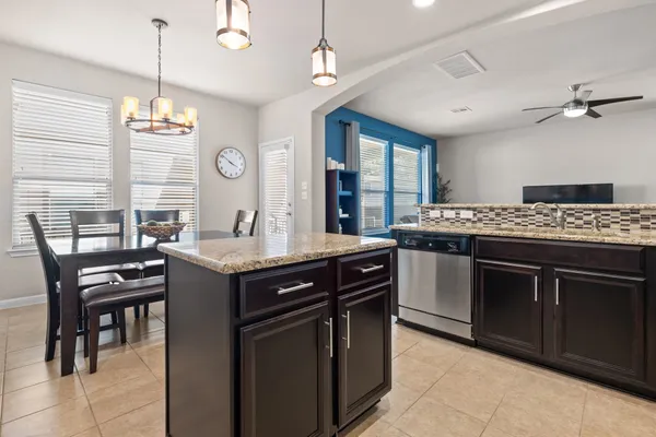 a kitchen with a stove a sink a dining table and chairs