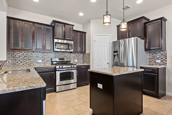 a kitchen with stainless steel appliances granite countertop a sink stove and refrigerator