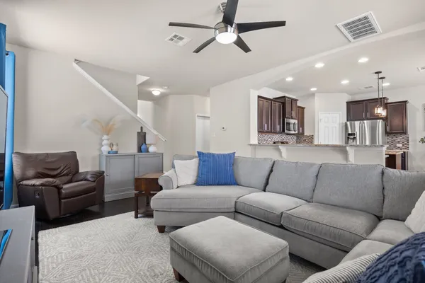a living room with furniture kitchen and a chandelier
