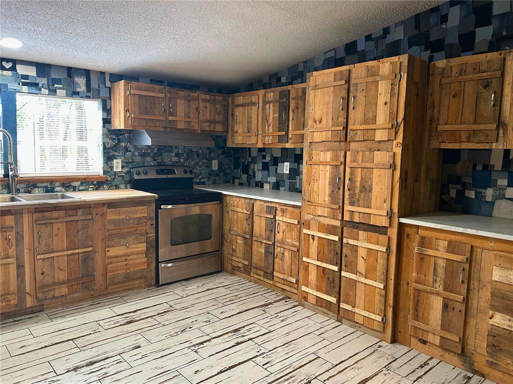 9867 Jerome Drive New Port Richey, FL 34654 - Photo 15 of 30 a kitchen with stainless steel appliances granite countertop a stove and a refrigerator