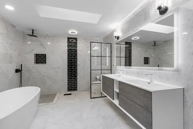 a bathroom with a double vanity sink a mirror and a bathtub