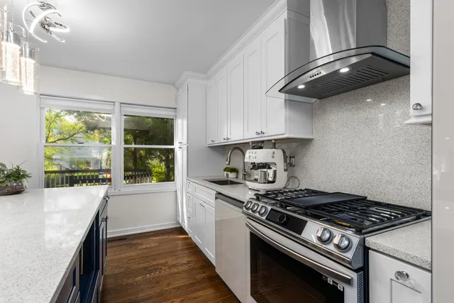a kitchen with a stove and a wooden floor