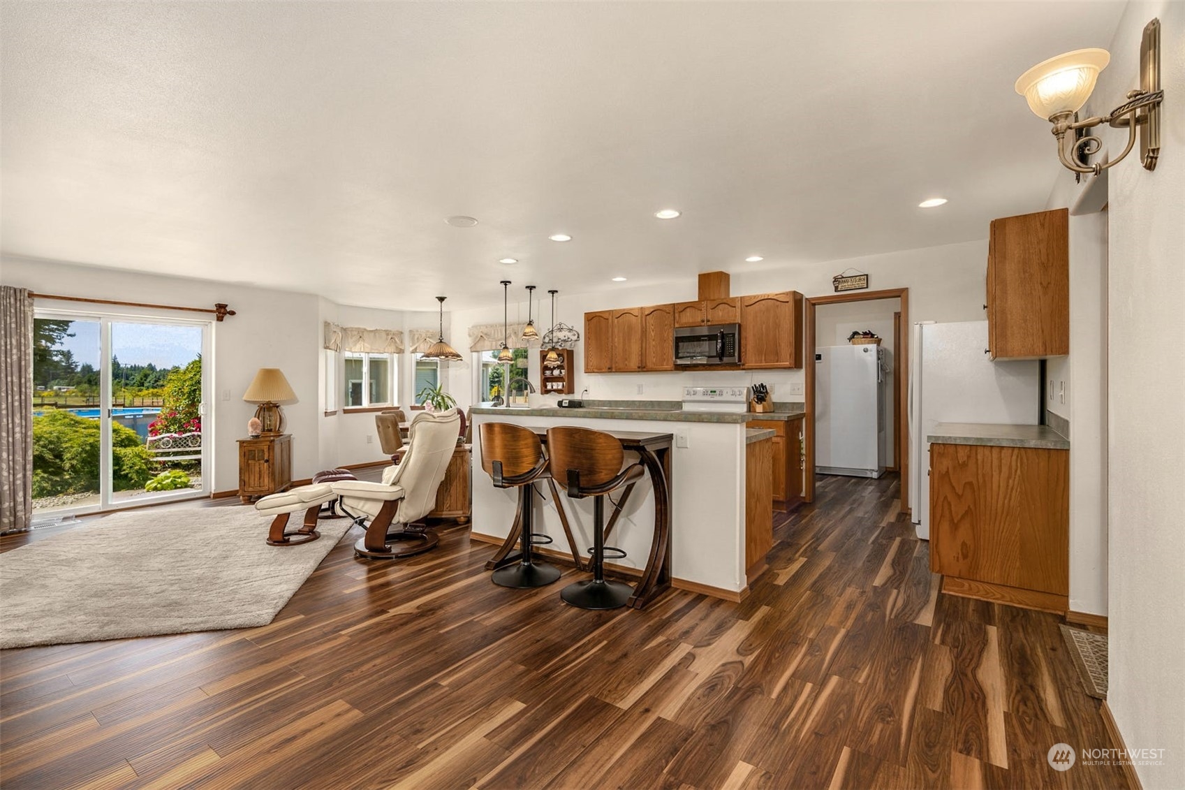 16401 Sheldon Lane Southwest Rochester, WA 98579 - Photo 4 of 40 a view of a kitchen with kitchen island wooden floors appliances and furniture