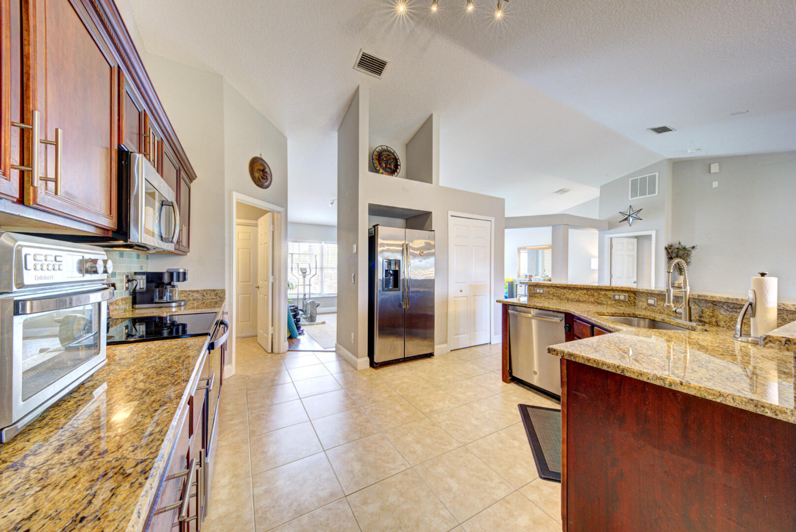 1029 Southwest Bay State Road Port St. Lucie, FL 34953 - Photo 20 of 39 a large kitchen with stainless steel appliances granite countertop a large counter top a stove and a refrigerator