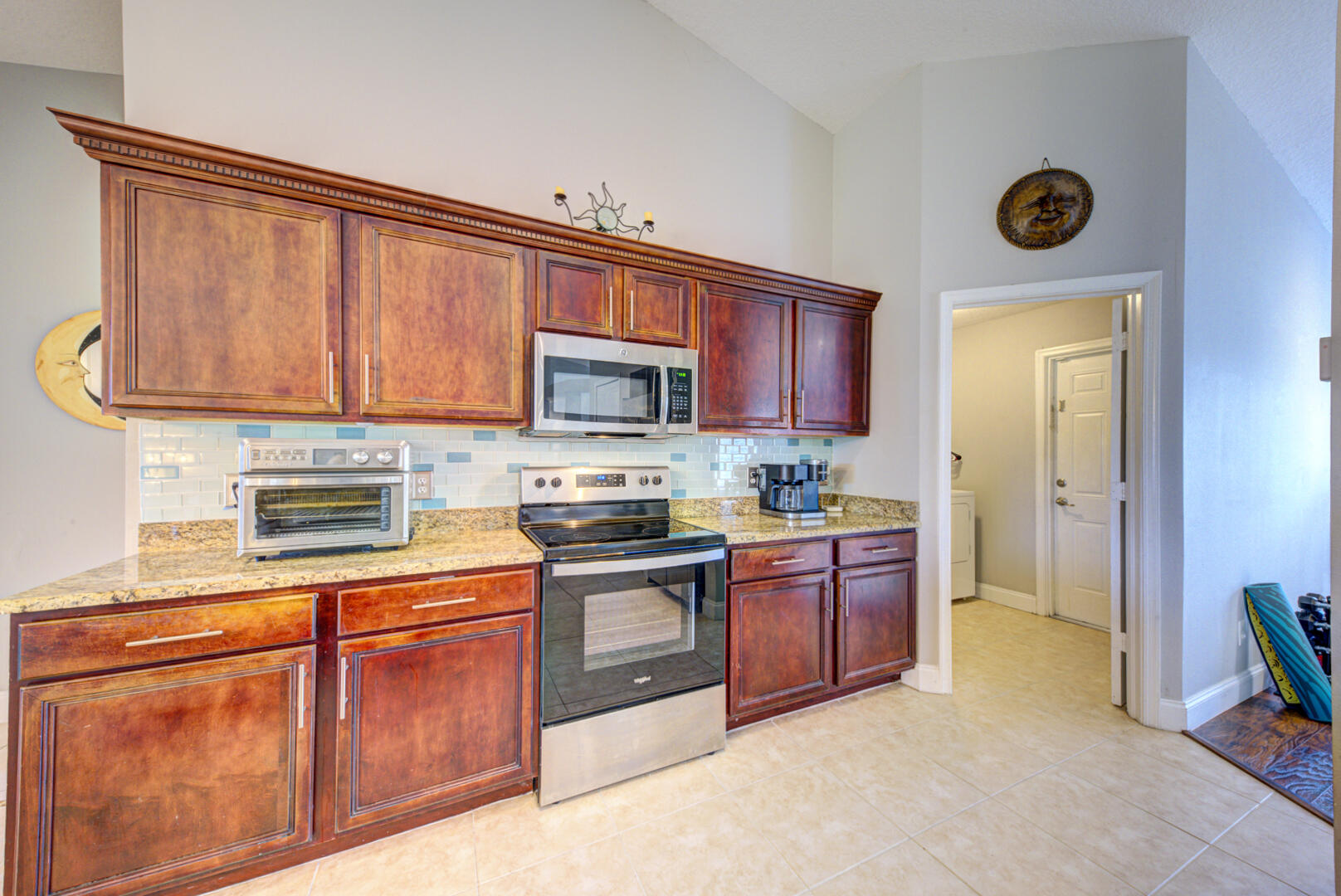 1029 Southwest Bay State Road Port St. Lucie, FL 34953 - Photo 21 of 39 a kitchen with stainless steel appliances granite countertop a stove microwave and sink