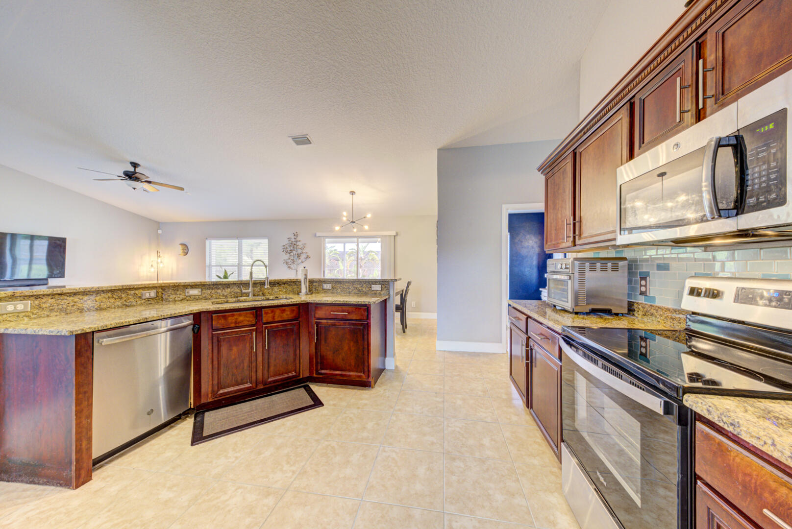 1029 Southwest Bay State Road Port St. Lucie, FL 34953 - Photo 22 of 39 a large kitchen with stainless steel appliances granite countertop a stove and a sink