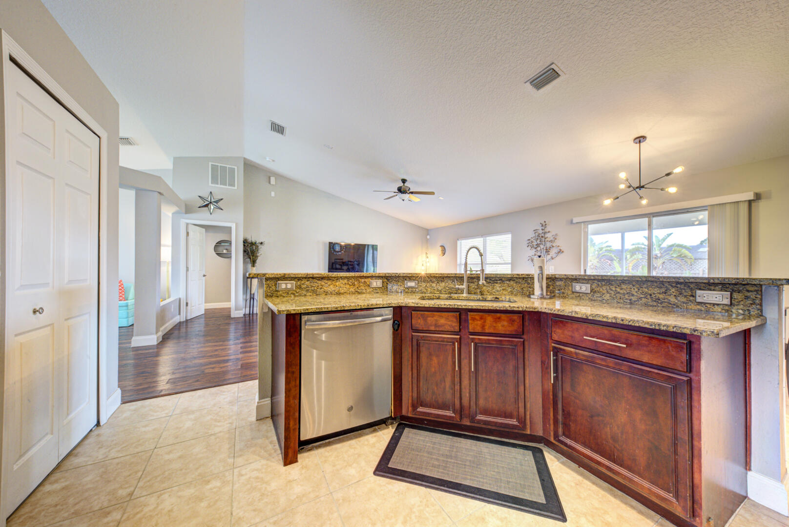 1029 Southwest Bay State Road Port St. Lucie, FL 34953 - Photo 24 of 39 a kitchen with stainless steel appliances granite countertop a stove a sink dishwasher and a refrigerator with wooden floor