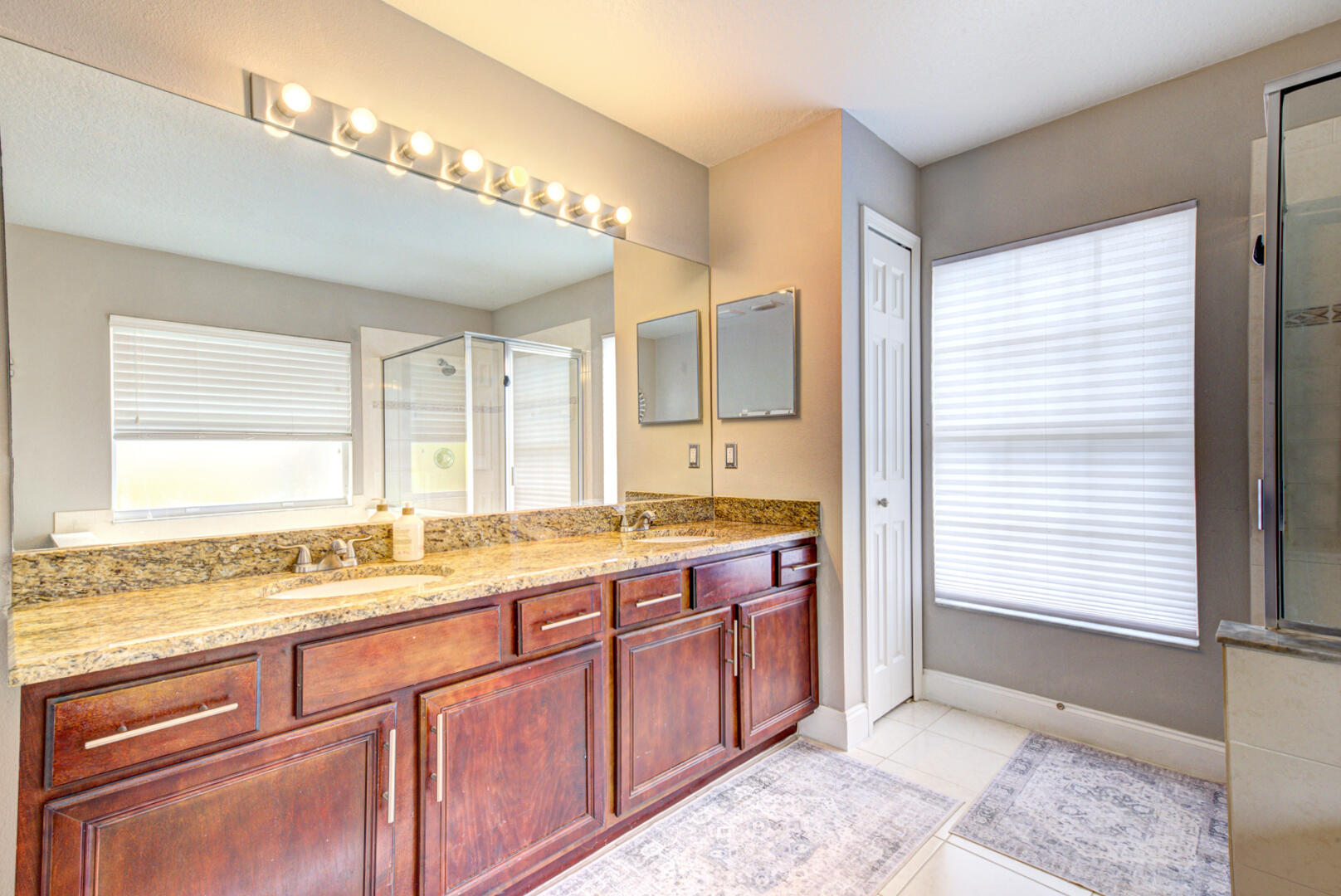 1029 Southwest Bay State Road Port St. Lucie, FL 34953 - Photo 29 of 39 a spacious bathroom with a granite countertop sink and a large mirror