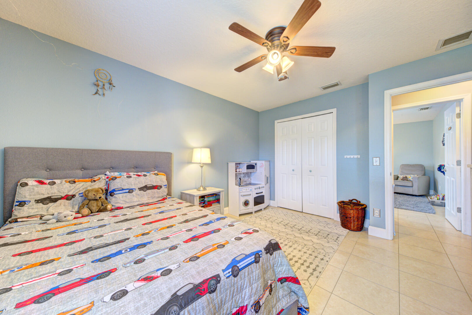 1029 Southwest Bay State Road Port St. Lucie, FL 34953 - Photo 31 of 39 a bedroom with a bed and a chandelier