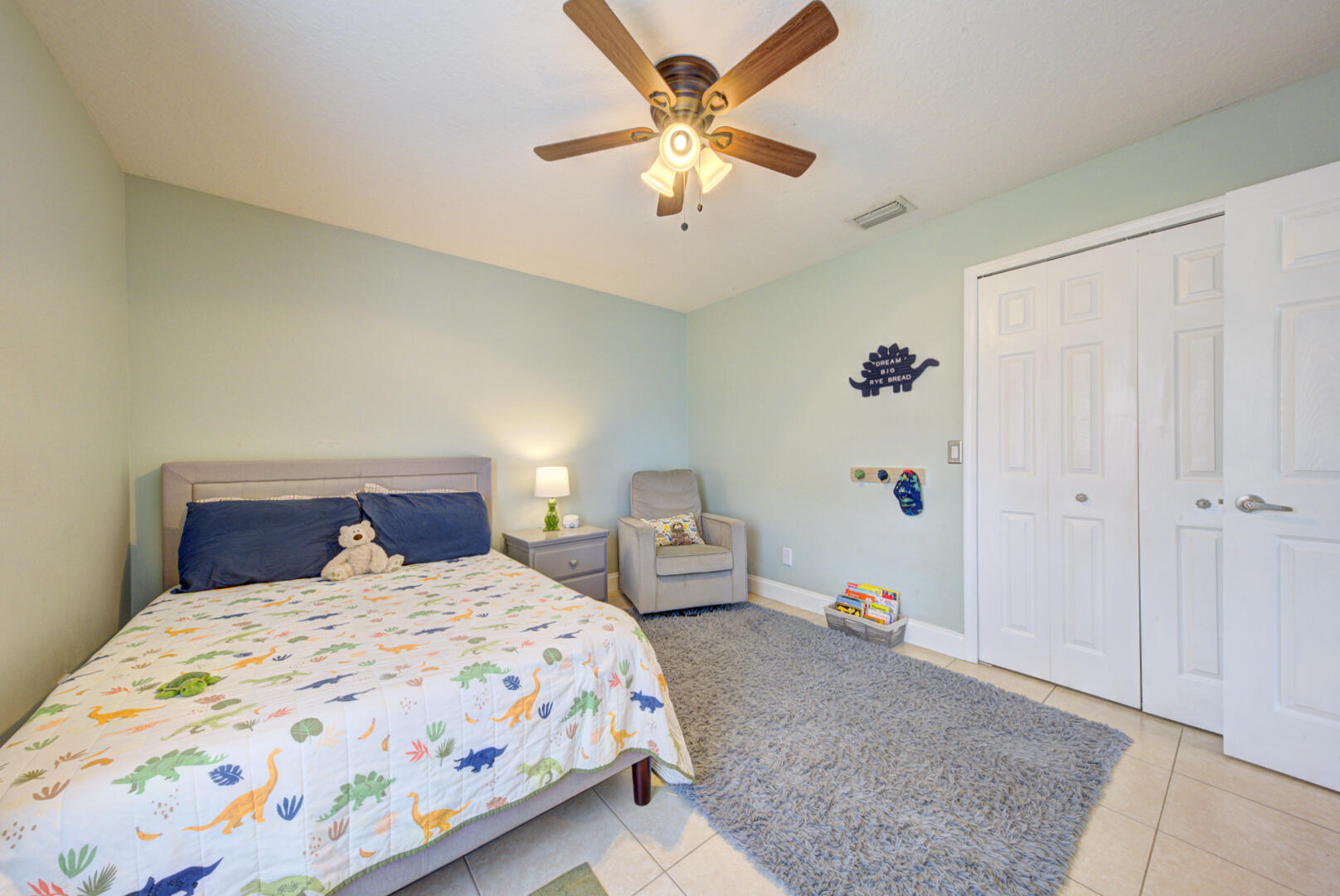 1029 Southwest Bay State Road Port St. Lucie, FL 34953 - Photo 34 of 39 a bedroom with a bed and a chandelier