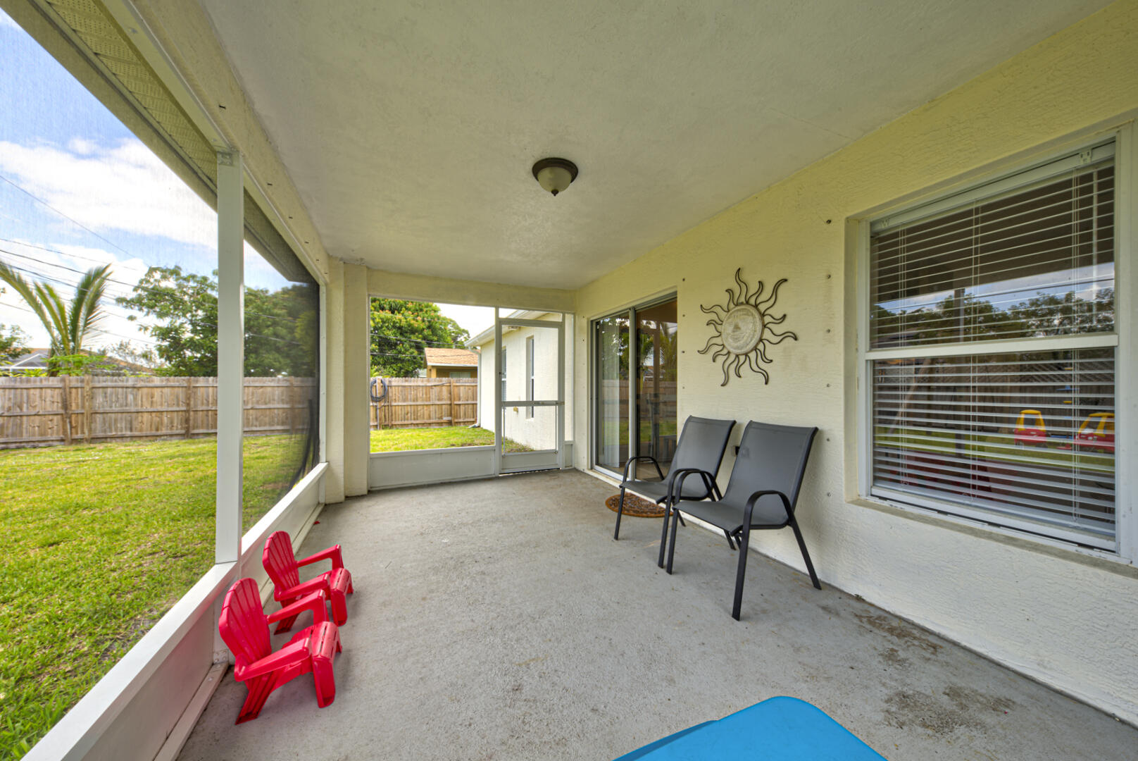 1029 Southwest Bay State Road Port St. Lucie, FL 34953 - Photo 36 of 39 a living room with patio furniture and a yard