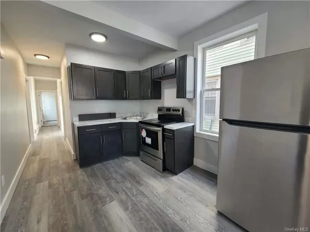 a kitchen with stainless steel appliances granite countertop a refrigerator and a stove