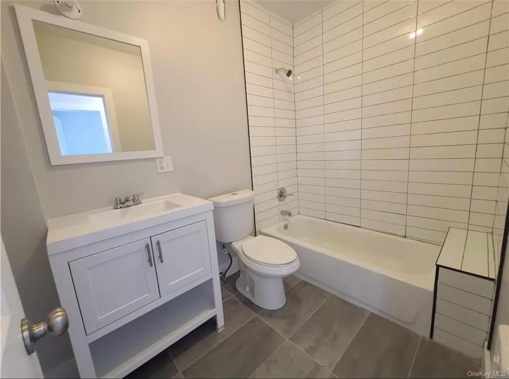 29 Hooker Avenue, Unit 2 Poughkeepsie, NY 12601 - Photo 6 of 9 a bathroom with a toilet a sink a mirror and bathtub