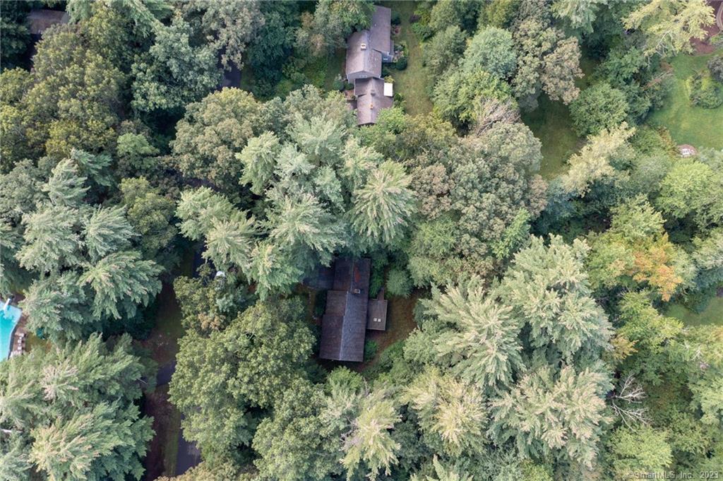 an aerial view of a house with a yard and large trees