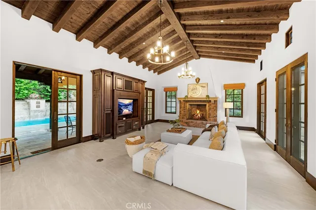 a living room with furniture a flat screen tv and a chandelier