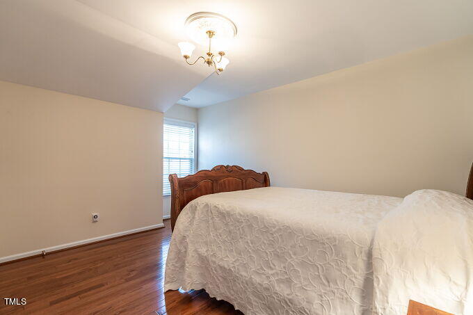 3742 Old Post Road Raleigh, NC 27612 - Photo 29 of 35 a bedroom with a bed and wooden floor