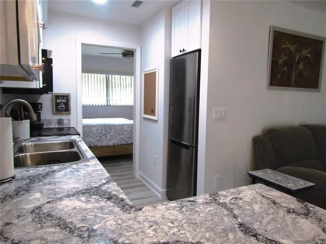 a bedroom with a bed and a refrigerator