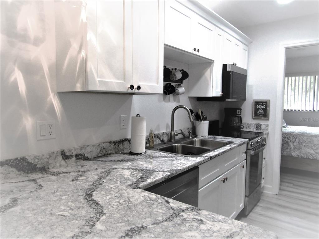 3531 Longmeadow, Unit 16 Sarasota, FL 34235 - Photo 12 of 29 a kitchen with stainless steel appliances granite countertop a sink stove and cabinets