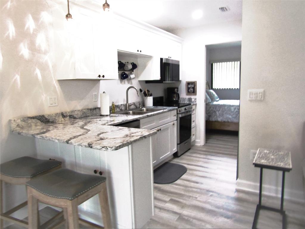 3531 Longmeadow, Unit 16 Sarasota, FL 34235 - Photo 14 of 29 a kitchen with a sink cabinets and wooden floor