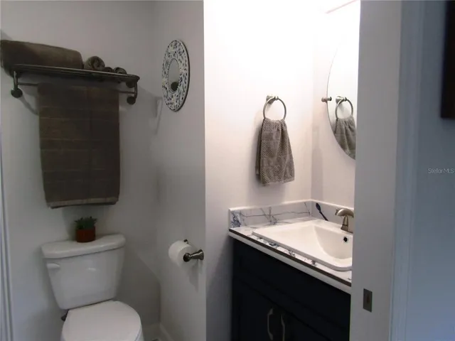 a bathroom with a toilet sink vanity and mirror