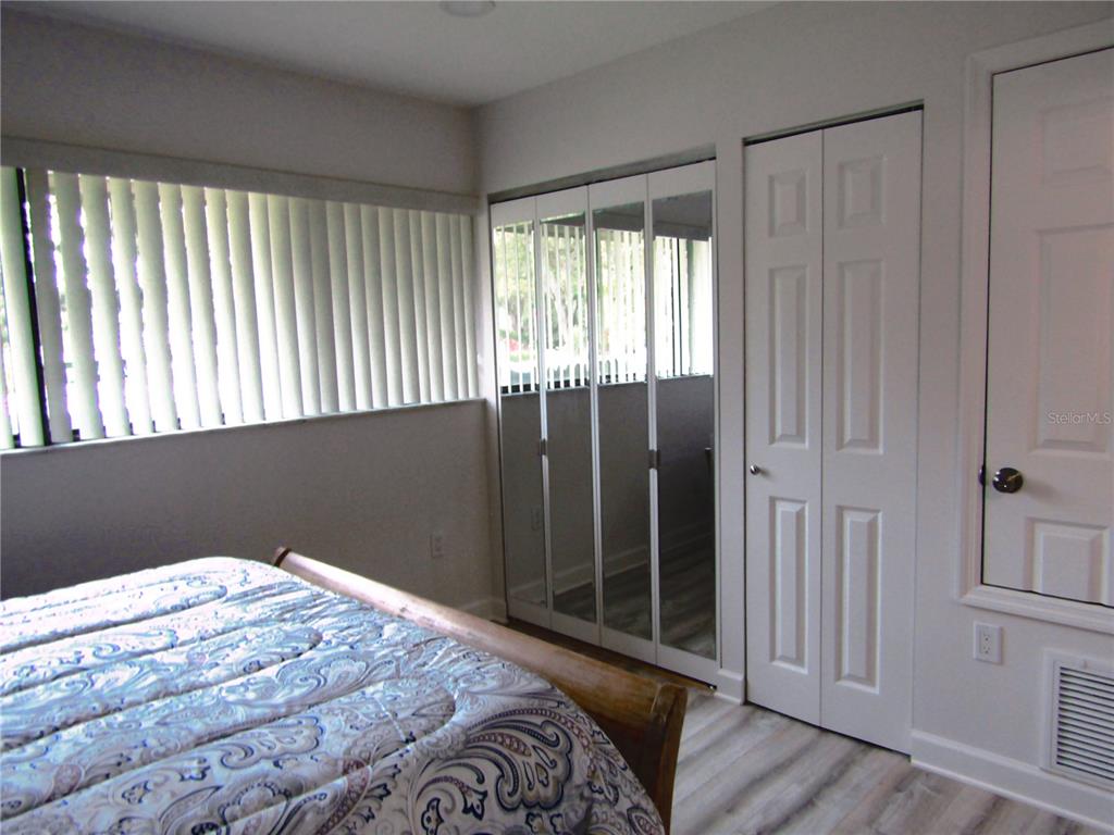 3531 Longmeadow, Unit 16 Sarasota, FL 34235 - Photo 19 of 29 a bedroom with a bed and wooden floor