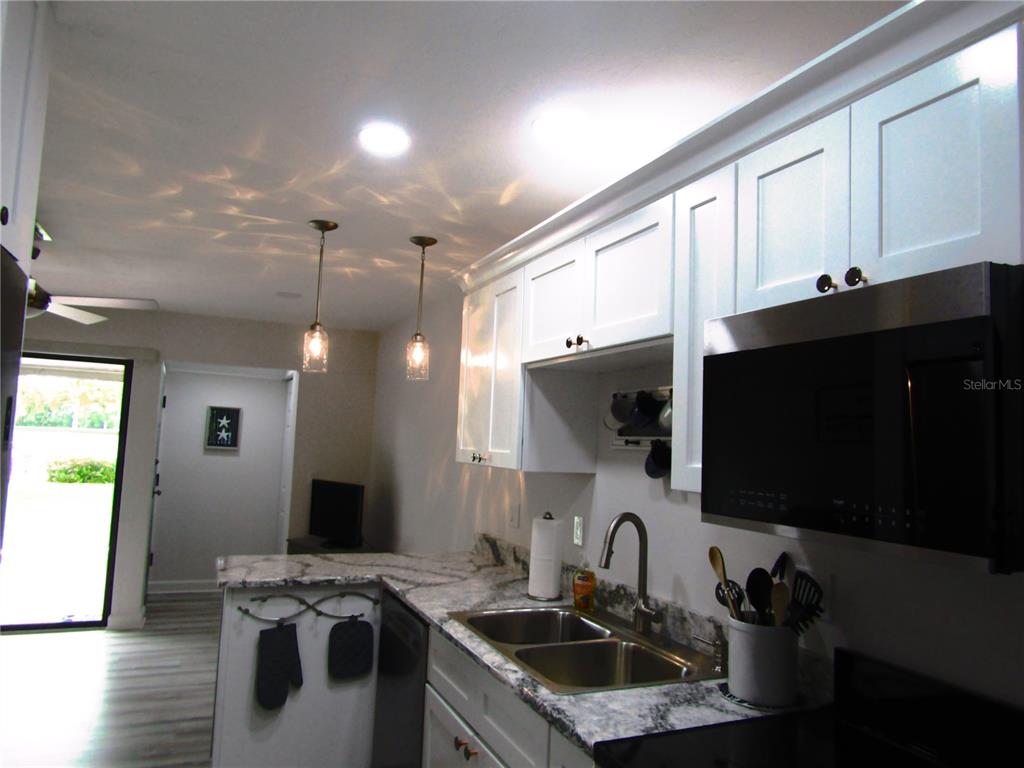 3531 Longmeadow, Unit 16 Sarasota, FL 34235 - Photo 23 of 29 a kitchen with stainless steel appliances granite countertop a sink a stove and a microwave